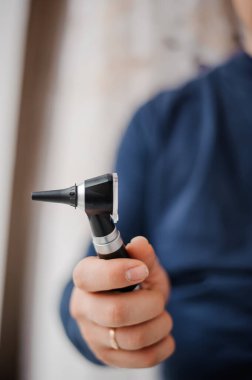 Otoskop bir otolaringolojistin elinde. Kulak ve orta kulağı incelemek için araç