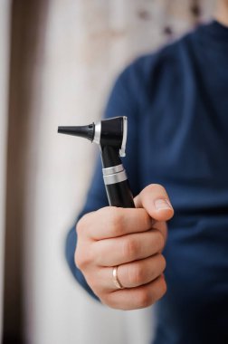 Otoskop bir otolaringolojistin elinde. Kulak ve orta kulağı incelemek için araç
