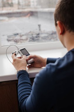 Parmak nabız oksimetresi kullanan bir adam, sağlık izleme konsepti. Beyaz arkaplanda nabız oksimetresi