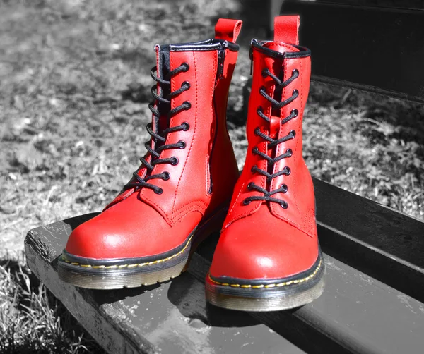 红色系带的靴子，在公园中的黑色白色背景上 — 图库照片