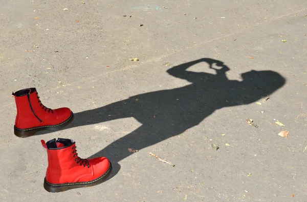 Rode schoenen en kind schaduw — Stockfoto