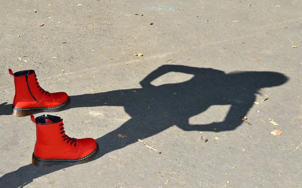Красная обувь и детская тень — стоковое фото