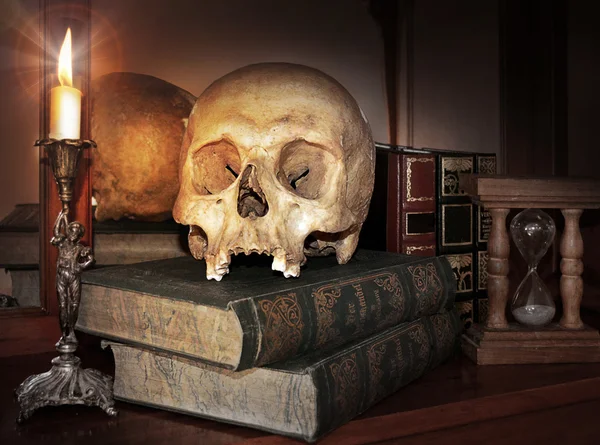 Вінтажний череп на антикварній книзі зі свічкою та пісочним годинником — стокове фото