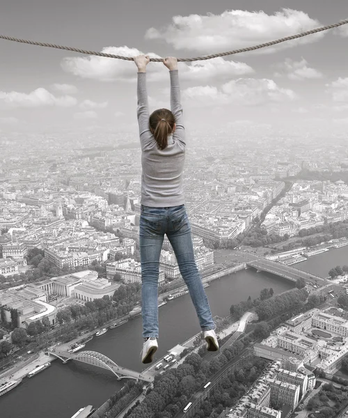 Žena visí na laně nad městem — Stock fotografie