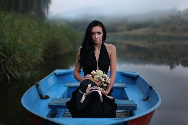 Beautiful girl reading a book on a boat in the lake — Stock Photo, Image