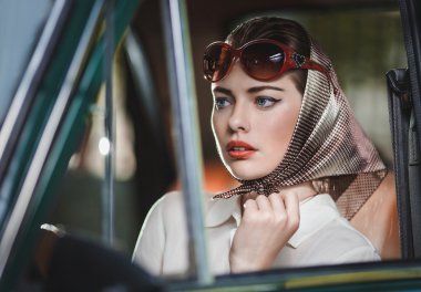 arabanın ön koltuğunda kameraya bakarak bir çekici genç bir kadın kız