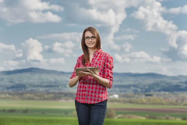 Mooie elegante vrouw permanent op een groene weide — Stockfoto