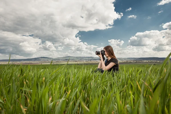 Beautiful elegant woman standing on a green meadow — Stock Photo, Image