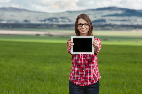 Schöne elegante Frau steht auf einer grünen Wiese — Stockfoto