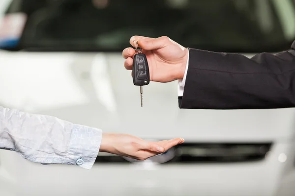 Ahora este coche es tuyo. Vendedor de coches dando la llave al dueño del coche nuevo —  Fotos de Stock