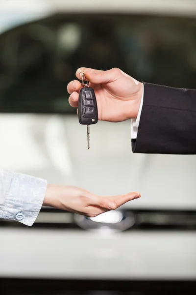 Now this car is yours. Car salesman giving the key to the new car owner — Stock Photo, Image