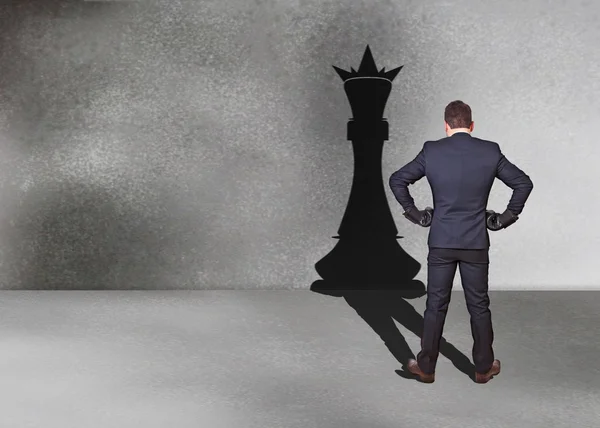 Бизнесмен с тенью шахматного короля — стоковое фото