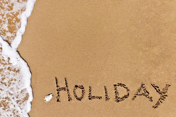 Written holiday drawn on the sand Stock Picture