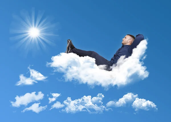 Geschäftsmann entspannt sich auf einer Wolke — Stockfoto