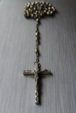 Rosary beads on brushed metal