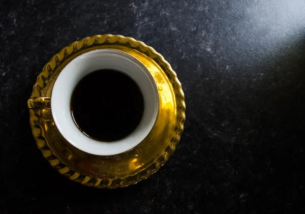 Taza de té de oro sobre fondo oscuro — Foto de Stock