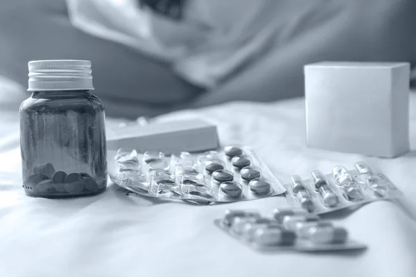 Yatakta depresyondaki genç bir kadın, dağınık saçlı. Çok fazla ilaç alıyor ve anksiyete ve umutsuzluk içinde..