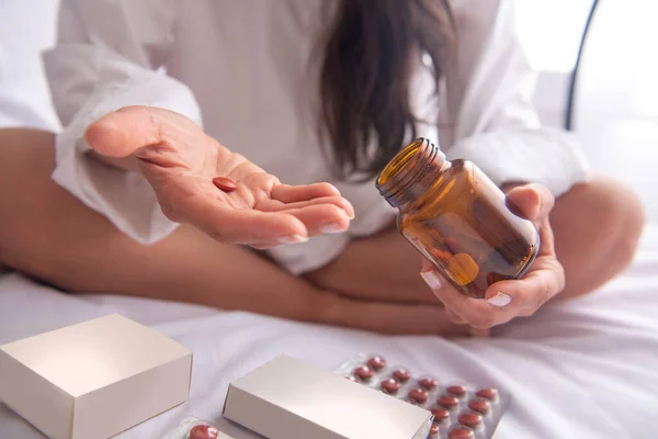 Yatakta depresif bir kadın, dağınık saçlı. Çok fazla ilaç alıyor ve anksiyete ve umutsuzluk içinde..