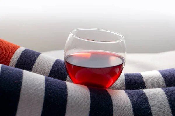 Çizgili çorap giyen ve elinde bir kadeh şarap tutan bir kadın.