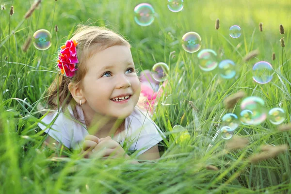 Glückliches kleines Mädchen spielt mit Blasen — Stockfoto