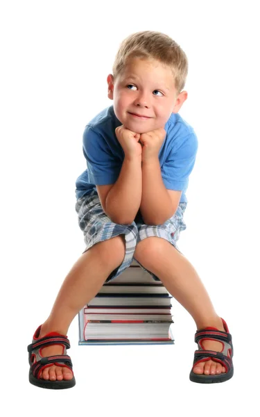 Niño sentado en libros — Foto de Stock