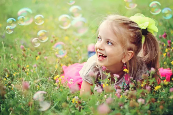 Glückliches kleines Mädchen spielt mit Blasen — Stockfoto