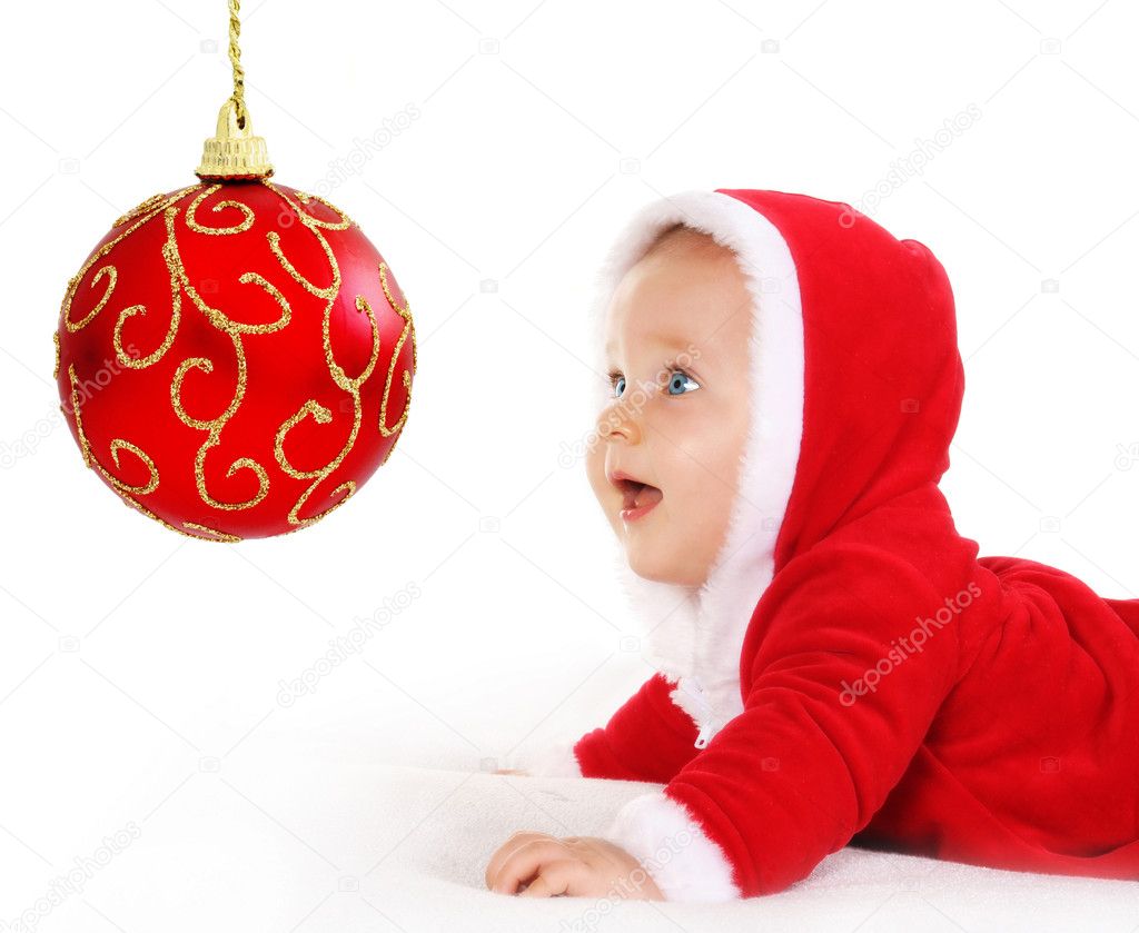 Christmas baby looking at a red ball