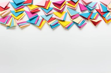 Resim üstte ve boş alanda birçok katlanmış kağıt üçgenine sahip soyut arkaplan.