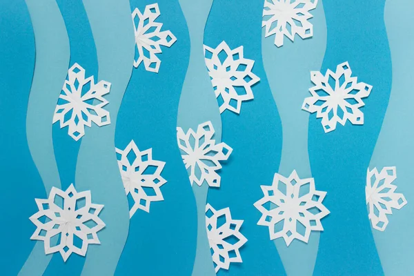 白い紙の雪片と青い紙の層が多いクリスマス手作りの紙の組成物 — ストック写真