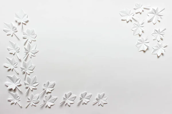 白い紙の折り畳んだ折り紙のカエデの葉がコーナーに配置された背景 コピー空白の画像 — ストック写真