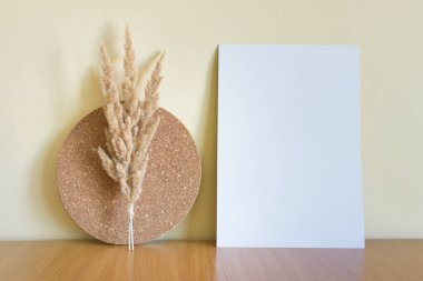 Dekoratif mantar çemberi ve kuru kabarık bitkilerle boş beyaz A4 kağıt kartıyla modelleme şablonu.