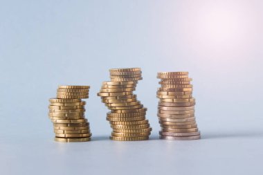 Mavi arkaplanda üç altın para destesini kapat.