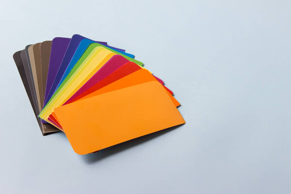 Stack of color example cards, pallette on blue background. Image with copy blank space.