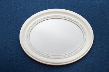 Mavi donanma desenli kumaş üzerinde oval beyaz çerçeveli model şablonu.