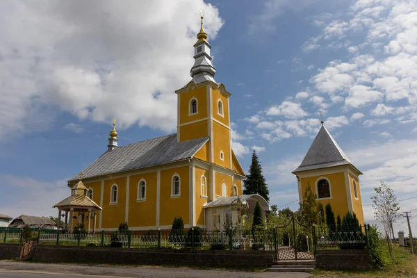 Kleine gele kerk in Oekraïne tegen blauwe hemel — Stockfoto