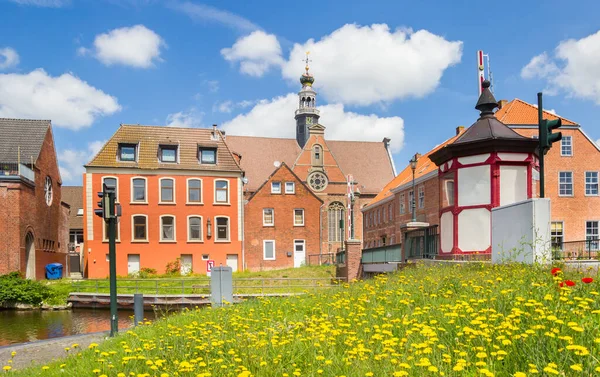 德国埃姆登一座历史性的新教堂前的黄色花朵 — 图库照片