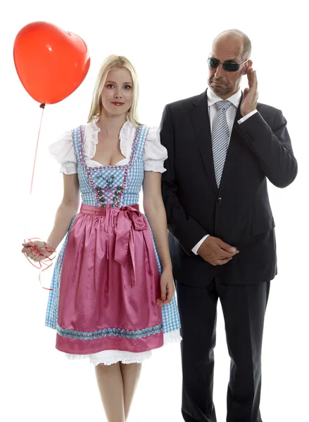 Woman in Dirndl with red heart balloon and Bodyguard — Stock Photo, Image