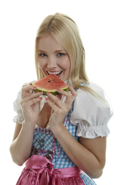 Kvinna i dirndl äter vattenmelon — Stockfoto