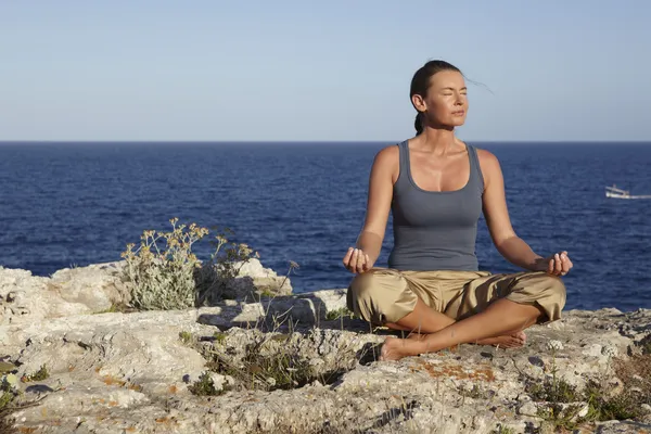 Yoga exercise on a rock — Stock Photo, Image