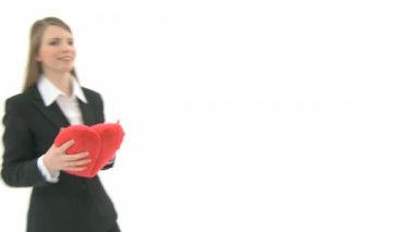 kadın kalp yastık kameraya atar.