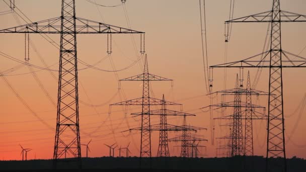 Atardecer turbina de viento y líneas de energía — Vídeos de Stock