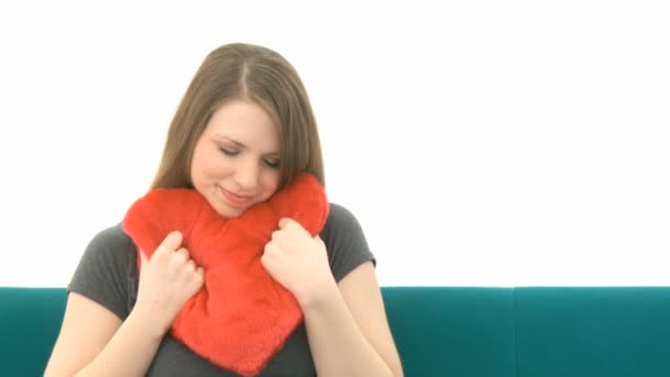 Woman cuddling with a heart pillow — Stock Video