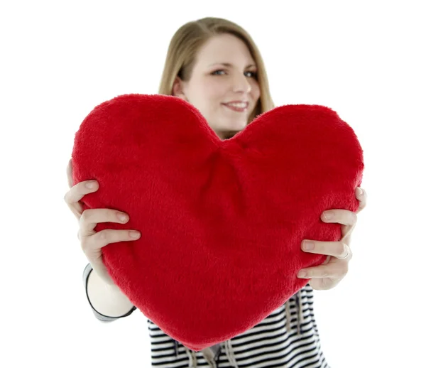 Mujer sonriendo con almohada en forma de corazón —  Fotos de Stock