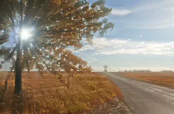 Estrada de trânsito solitária com raio de luz solar ao pôr do sol . — Fotografia de Stock