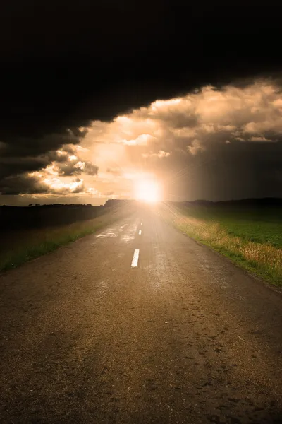 Route asphaltée et nuages orageux sombres au-dessus — Photo