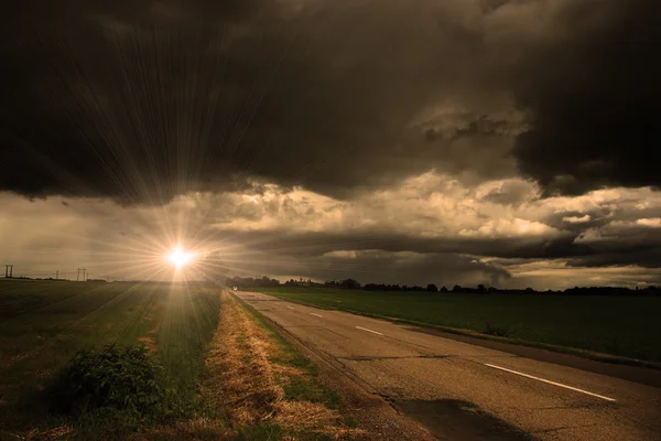 Camino de asfalto y nubes de tormenta oscura sobre él — Foto de Stock