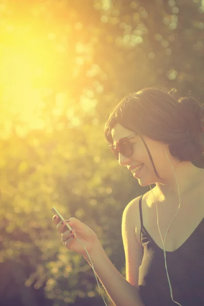 Flicka lyssna på musik genom hörlurar — Stockfoto