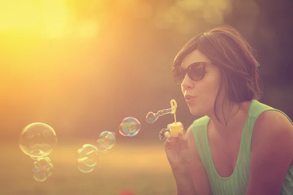 Mooie vrouw zeepbellen blazen — Stockfoto