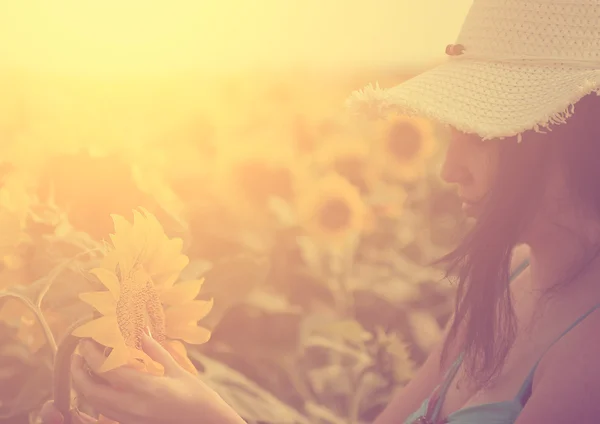 Mooie vrouw op het veld met zonnebloemen — Stockfoto