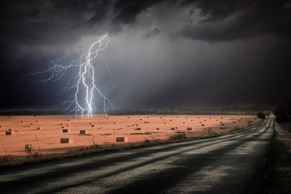 Lightning storm over asphalt road